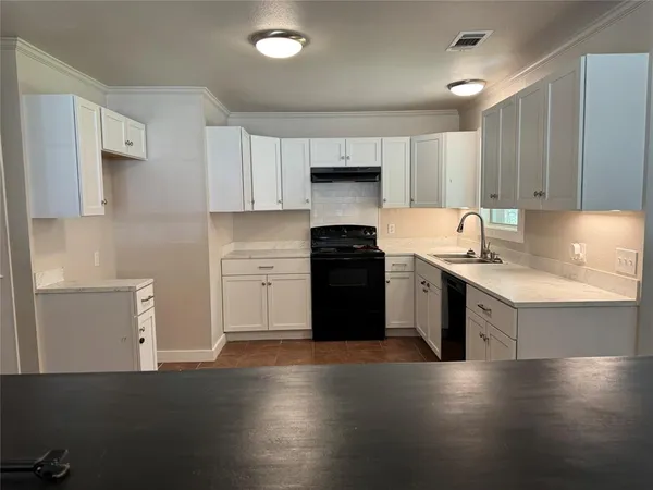 an empty room with wooden floor chandelier fan and windows