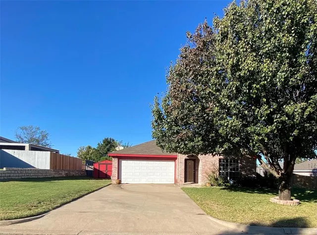 a view of a house with a yard and tree