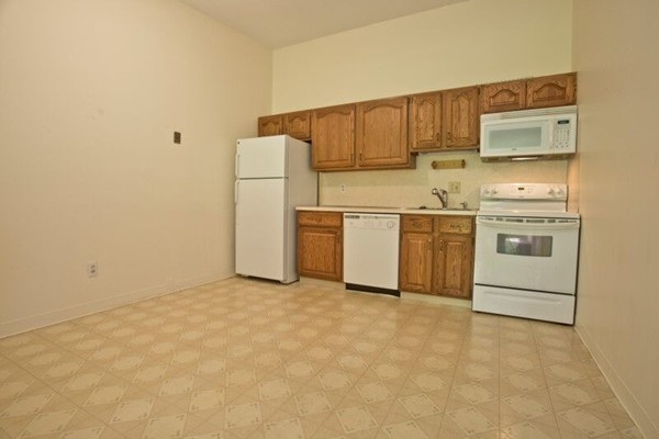 74 Beach Street, Unit 211 Woburn, MA 01801 - Photo 2 of 14 a kitchen with stainless steel appliances white cabinets and a refrigerator