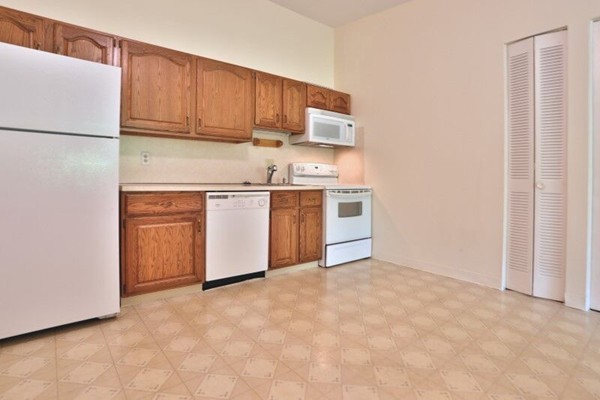 74 Beach Street, Unit 211 Woburn, MA 01801 - Photo 3 of 14 a kitchen with stainless steel appliances granite countertop a refrigerator a stove a sink and white cabinets