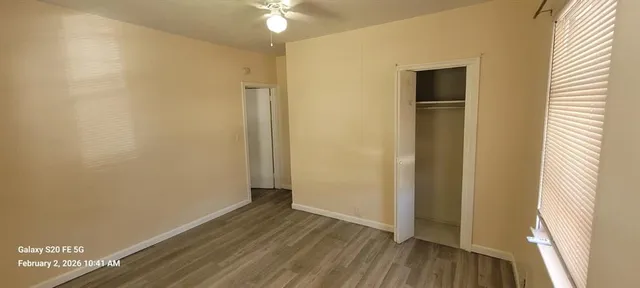 a view of a room with wooden floor and a window