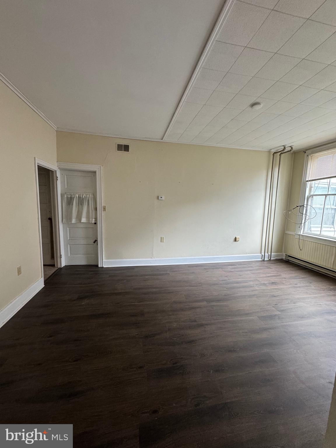 117 East State Street, Unit 1 Quarryville, PA 17566 - Photo 4 of 6 a view of an empty room with wooden floor and a window