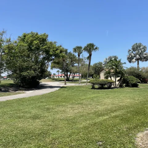 a view of a house with a big yard and large trees