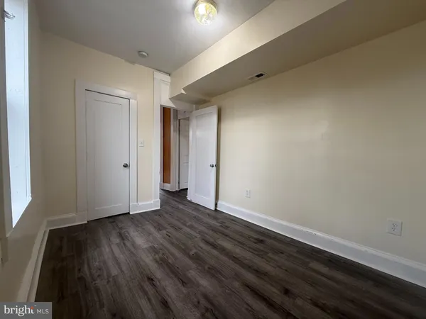 a view of a hallway with wooden floor and a chandelier