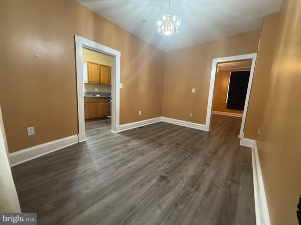a kitchen with stainless steel appliances granite countertop a refrigerator a sink a stove and a dining table with wooden floor