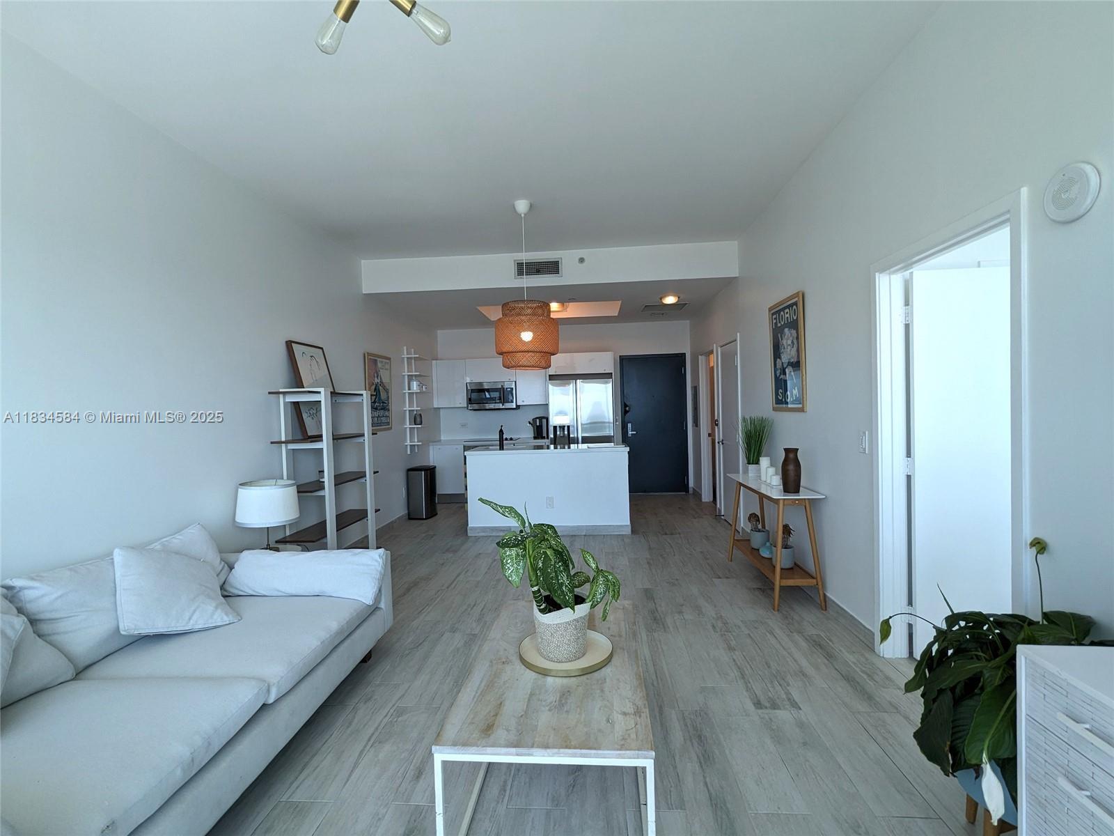 888 Biscayne Boulevard, Unit 4702 Miami, FL 33132 - Photo 11 of 27 a living room with furniture and a wooden floor