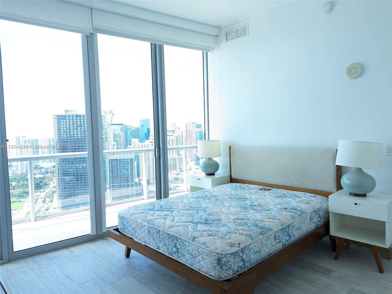 888 Biscayne Boulevard, Unit 4702 Miami, FL 33132 - Photo 22 of 27 a bedroom with a large bed and a large window