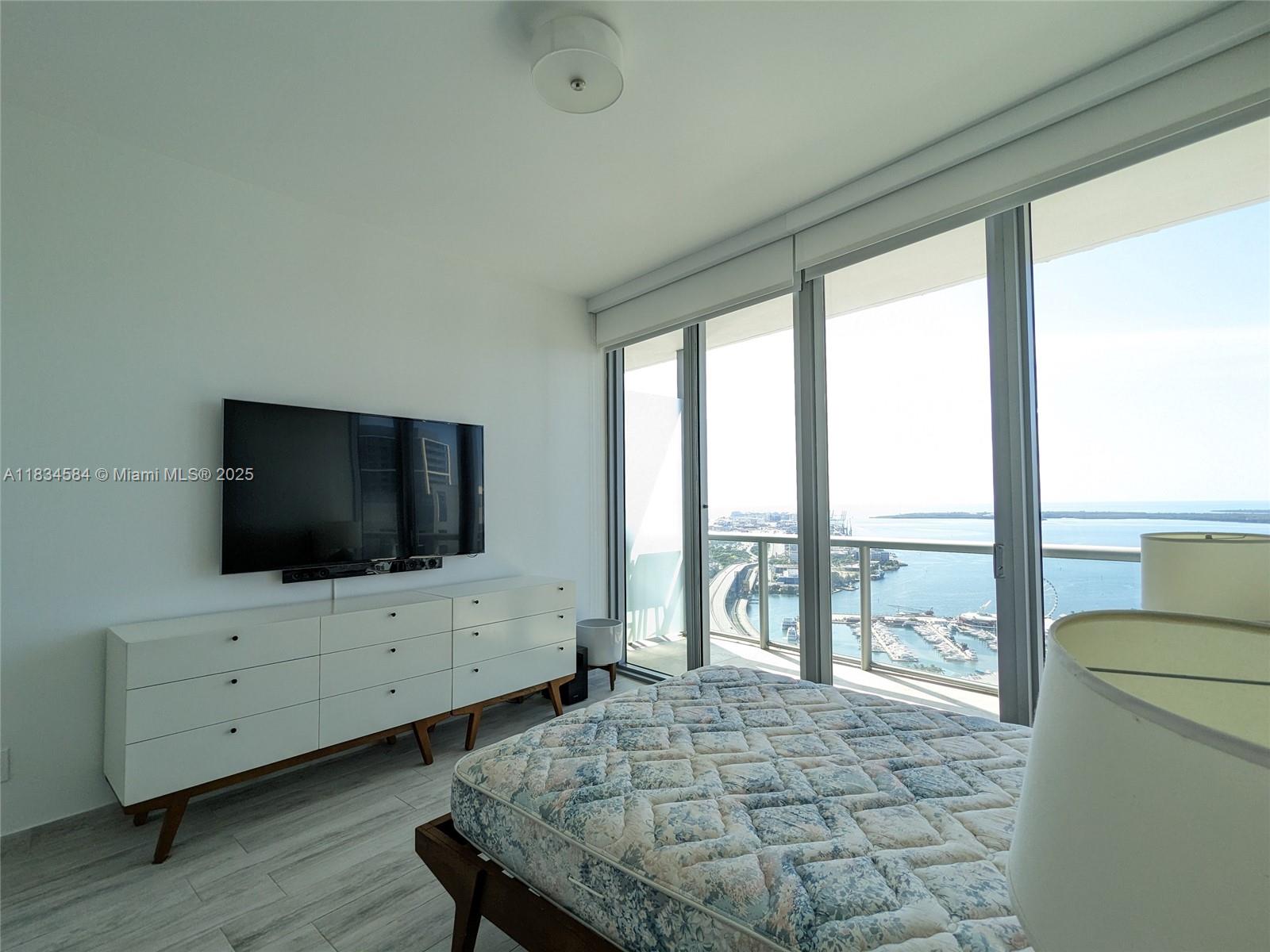 888 Biscayne Boulevard, Unit 4702 Miami, FL 33132 - Photo 25 of 27 a living room with furniture and a flat screen tv