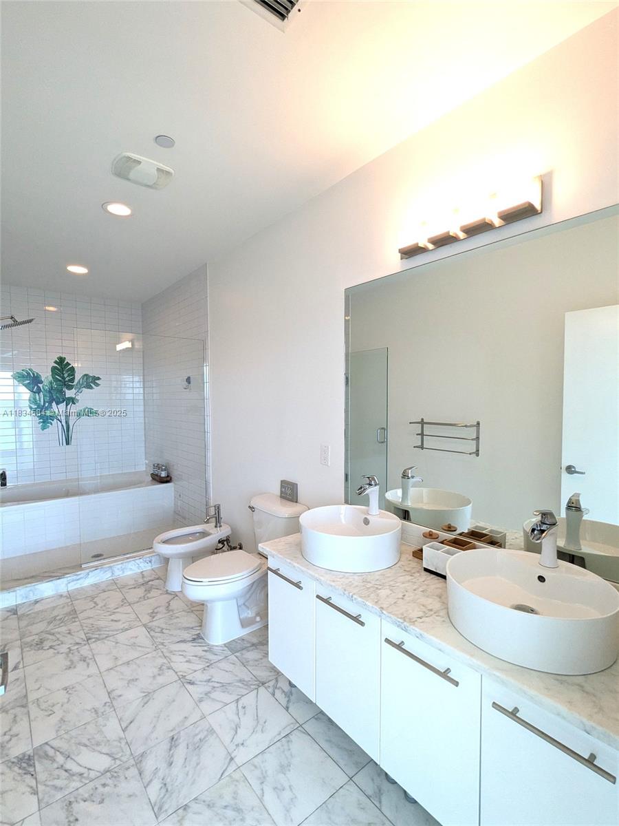 888 Biscayne Boulevard, Unit 4702 Miami, FL 33132 - Photo 26 of 27 a bathroom with a double vanity sink mirror and toilet