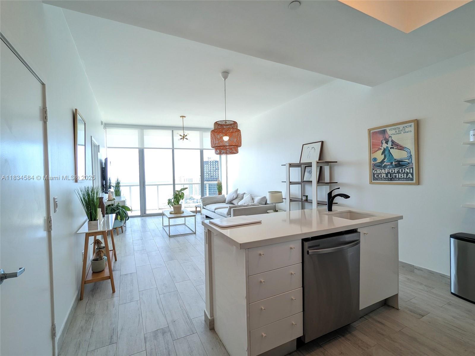 888 Biscayne Boulevard, Unit 4702 Miami, FL 33132 - Photo 3 of 27 a kitchen with a sink stove and wooden floor