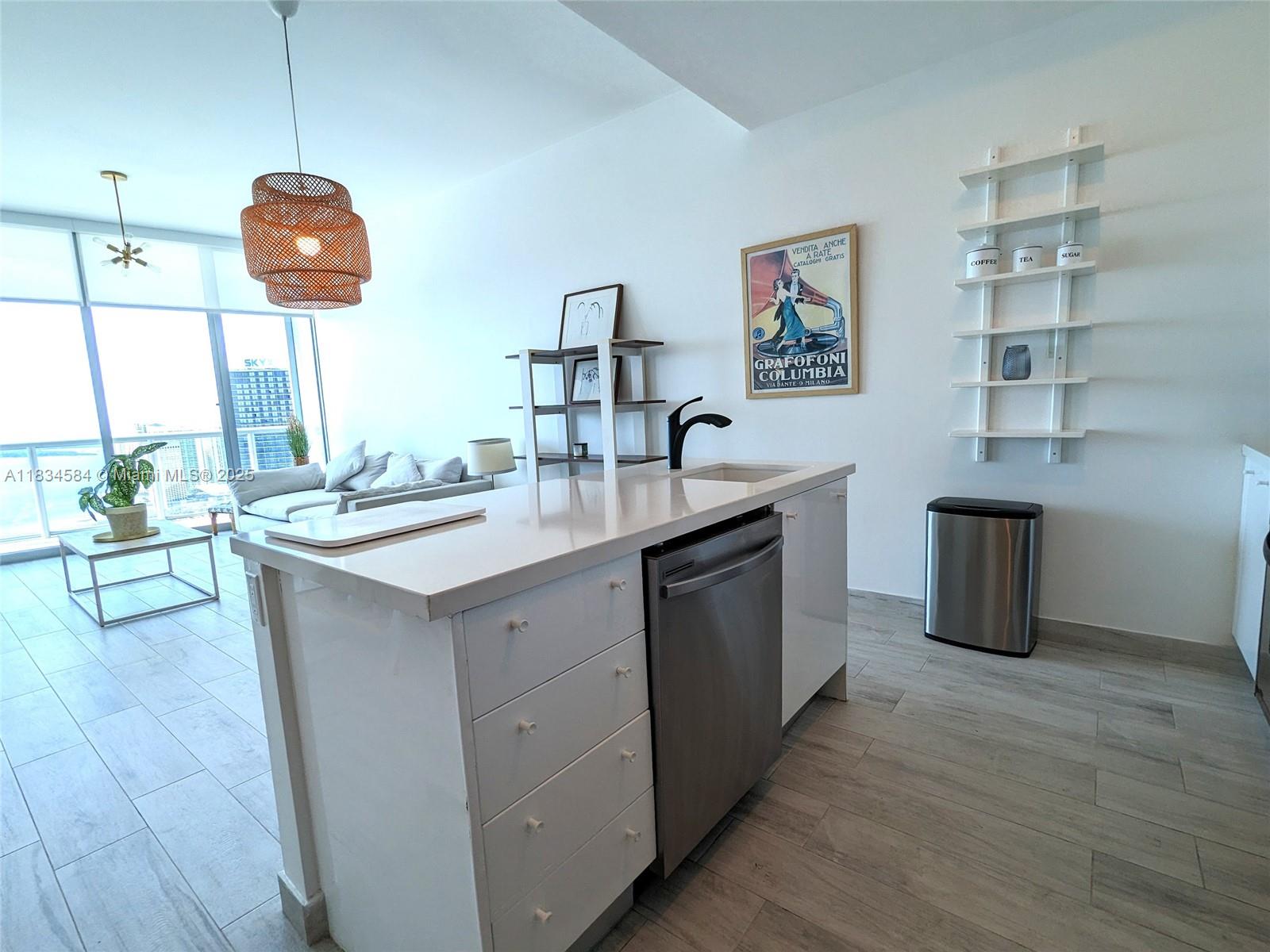 888 Biscayne Boulevard, Unit 4702 Miami, FL 33132 - Photo 5 of 27 a kitchen with a sink and a refrigerator