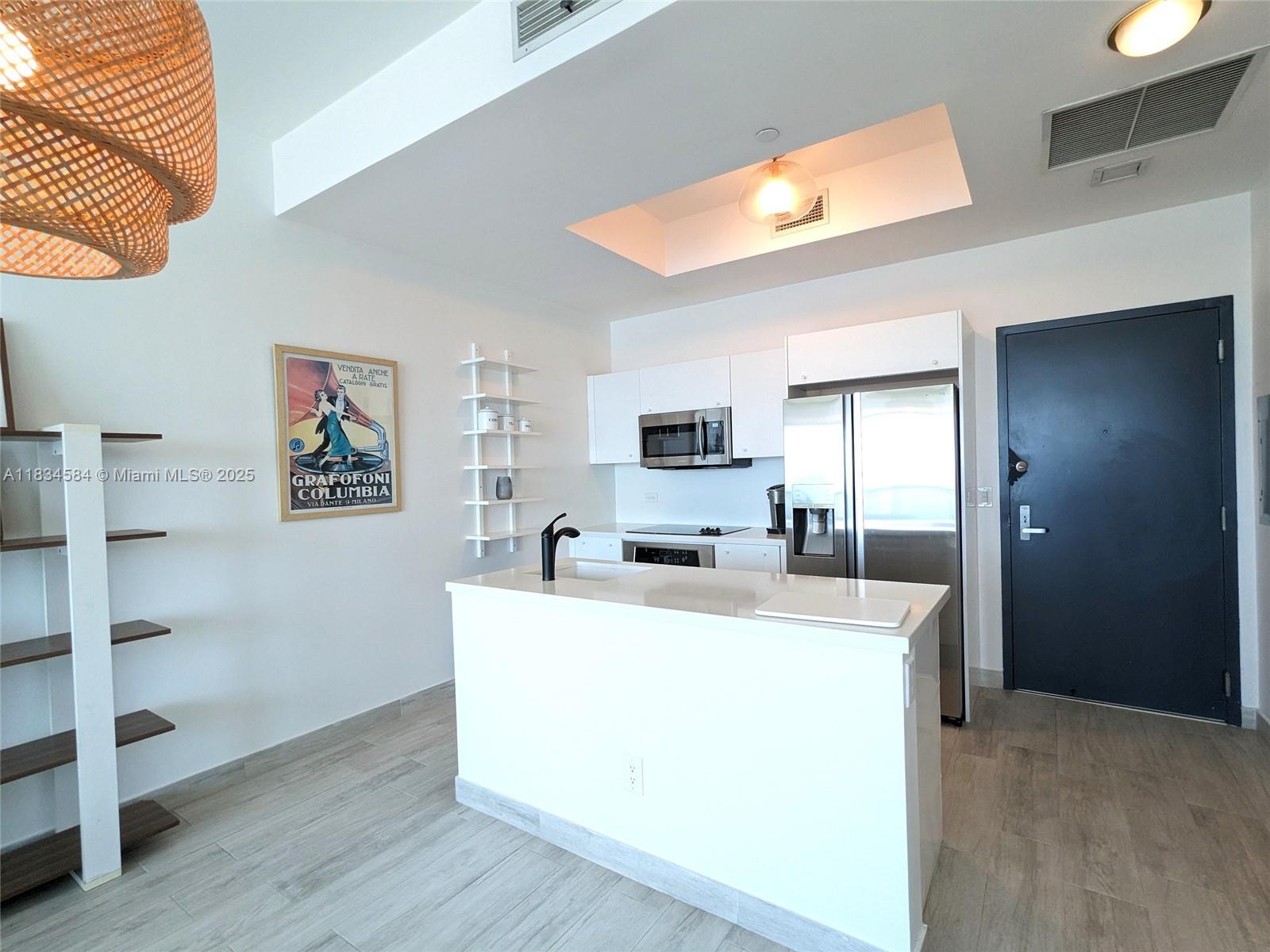 888 Biscayne Boulevard, Unit 4702 Miami, FL 33132 - Photo 6 of 27 a large white kitchen with wooden floor