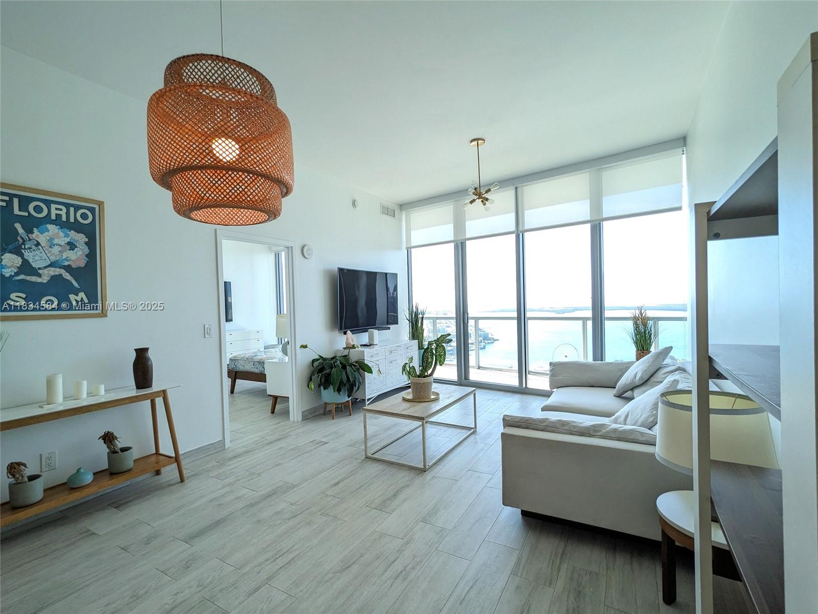 888 Biscayne Boulevard, Unit 4702 Miami, FL 33132 - Photo 9 of 27 a living room with furniture and a floor to ceiling window