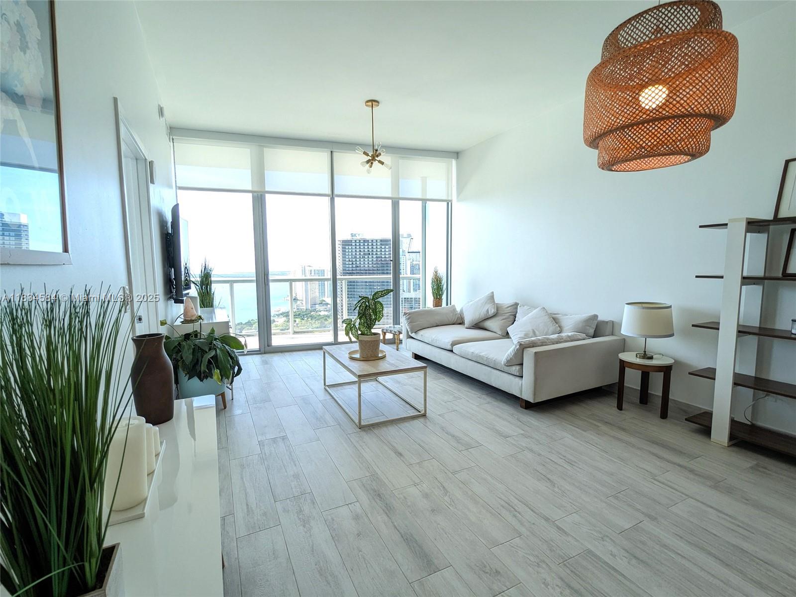 888 Biscayne Boulevard, Unit 4702 Miami, FL 33132 - Photo 10 of 27 a living room with furniture and a large window
