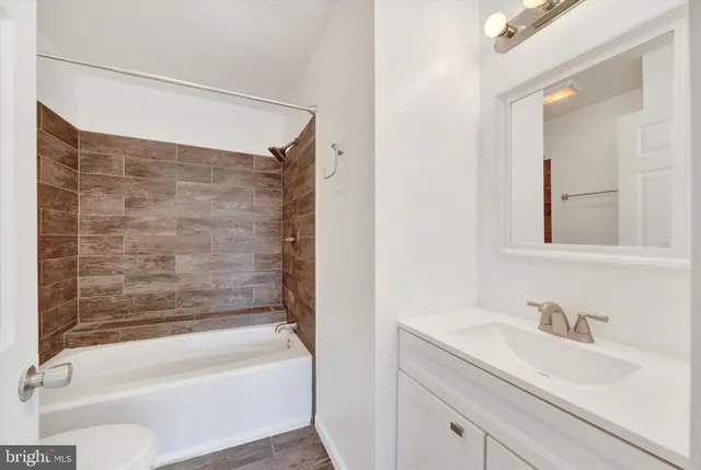 a bathroom with a granite countertop sink toilet and bathtub