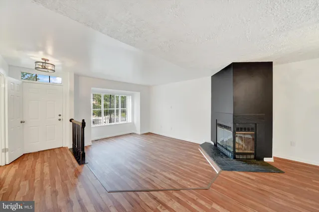 a view of empty room with wooden floor and window