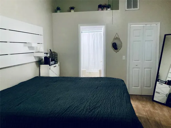a view of a hallway with wooden floor and a cabinet