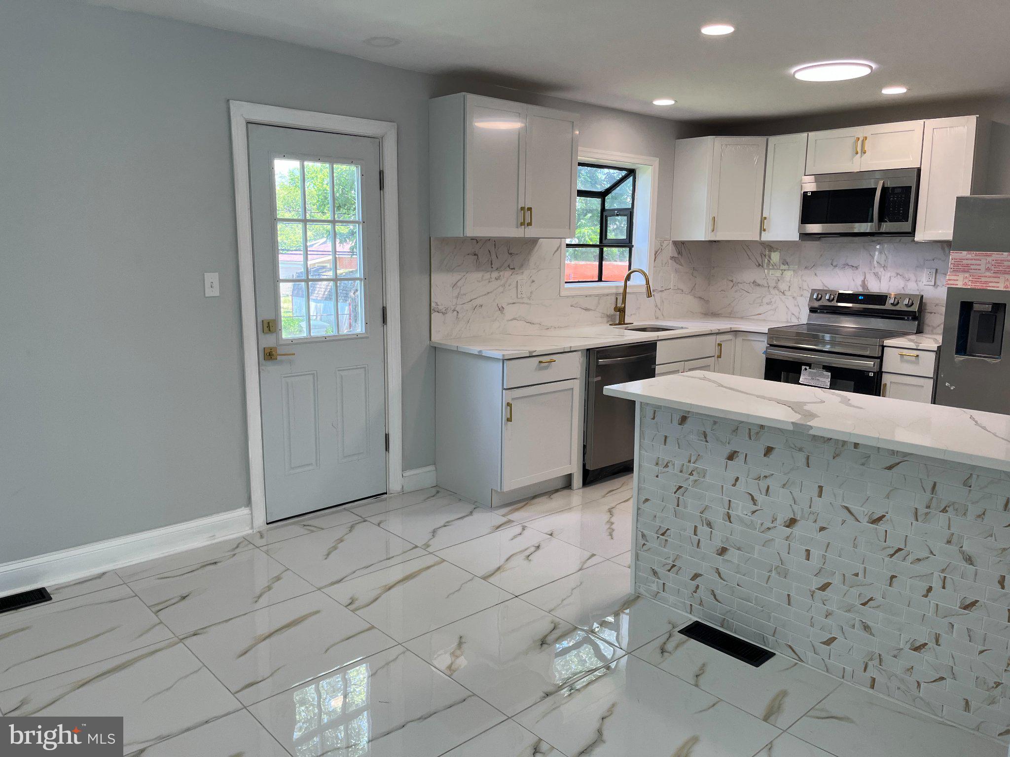 2405 Limestone Road Wilmington, DE 19808 - Photo 12 of 40 a kitchen with stainless steel appliances granite countertop a sink stove and cabinets