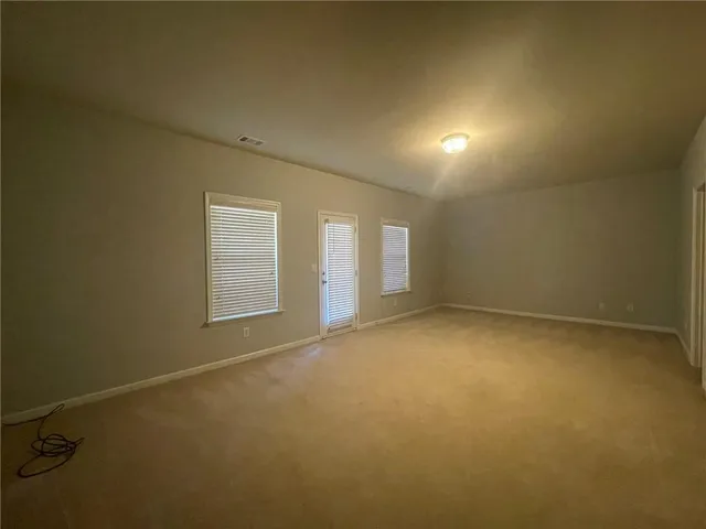 a view of a house with a large tree and wooden fence