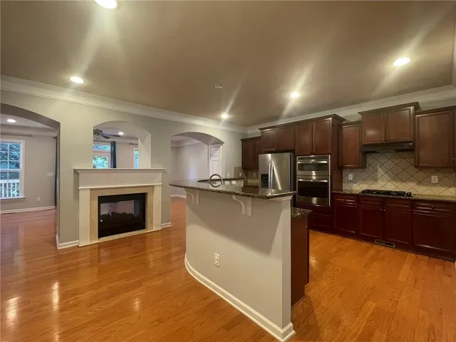 a kitchen with stainless steel appliances granite countertop a stove a sink and a refrigerator