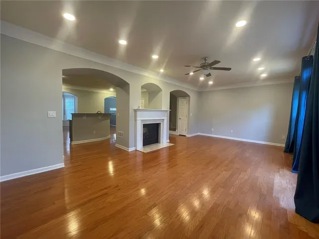 an empty room with wooden floor and fireplace
