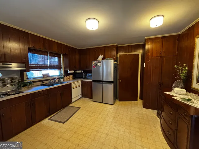 a kitchen with stainless steel appliances granite countertop a refrigerator and a sink