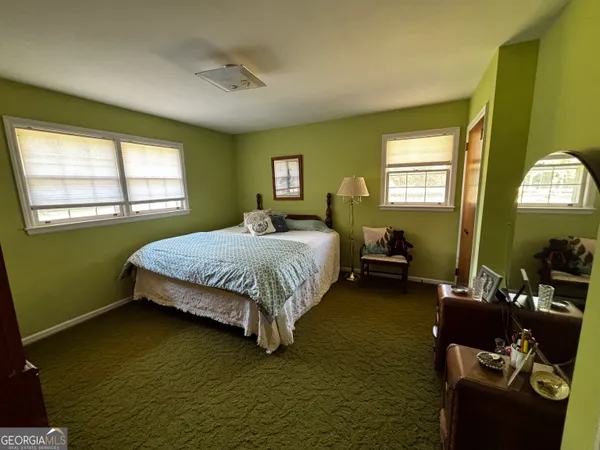 a bedroom with a bed wooden floor and window