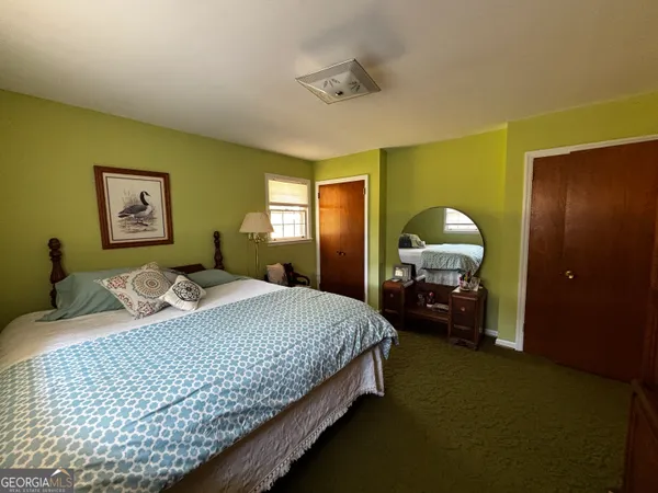 a bedroom with a bed and painting on the wall