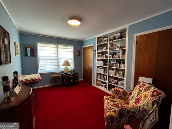 a bedroom with furniture and a large window