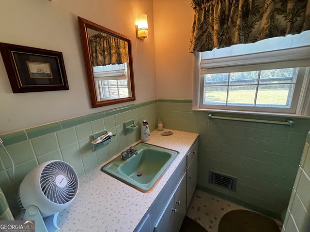 a bathroom with a sink a toilet and a mirror