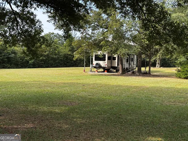 a view of a field with trees in the background
