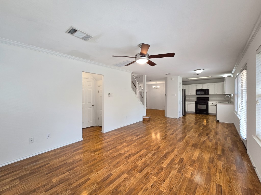 8021 Rimini Trail Austin, TX 78729 - Photo 12 of 26 a view of empty room with wooden floor and windows