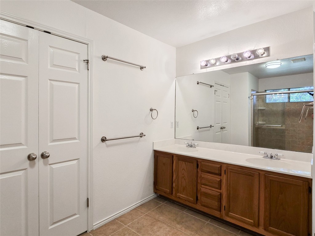 8021 Rimini Trail Austin, TX 78729 - Photo 19 of 26 a spacious bathroom with a double vanity sink a large mirror and shower
