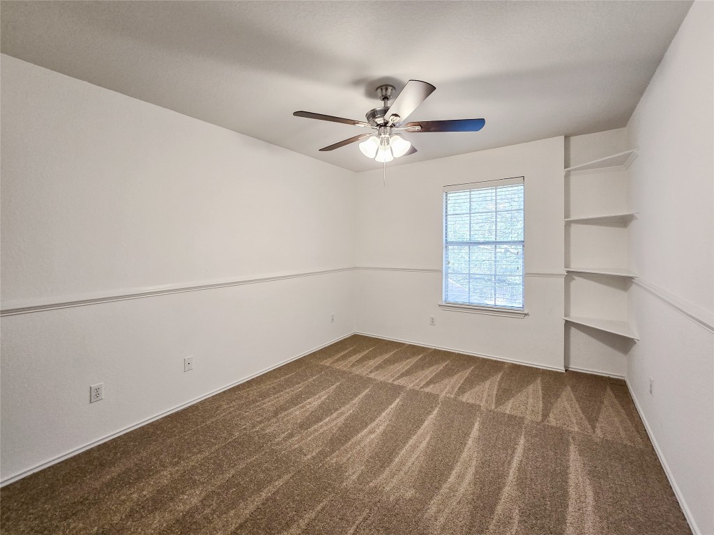 8021 Rimini Trail Austin, TX 78729 - Photo 23 of 26 a view of empty room with wooden floor and fan