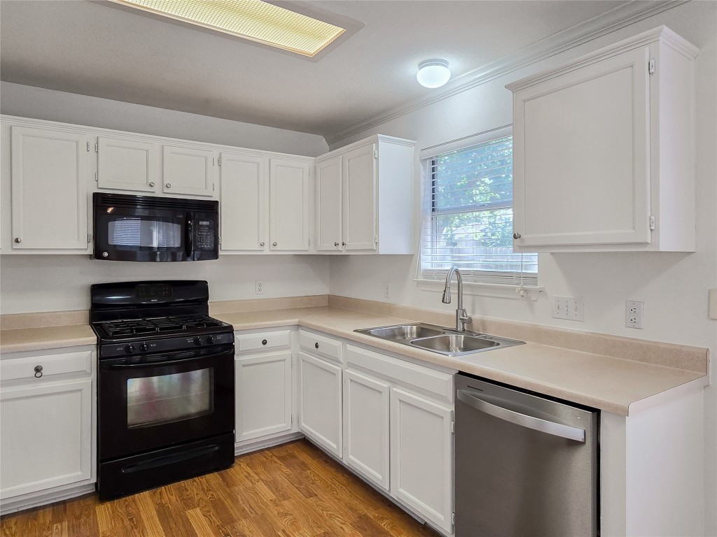 8021 Rimini Trail Austin, TX 78729 - Photo 8 of 26 a kitchen with a sink stove and microwave