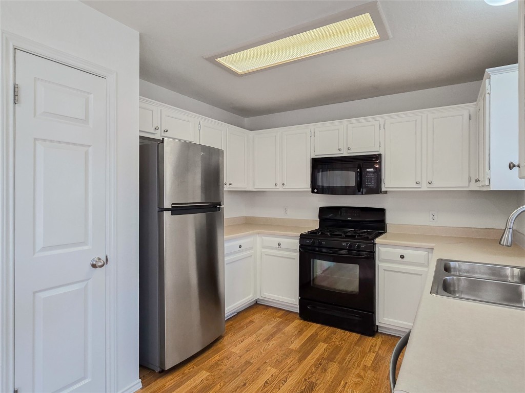 8021 Rimini Trail Austin, TX 78729 - Photo 9 of 26 a kitchen with a refrigerator stove and white cabinets