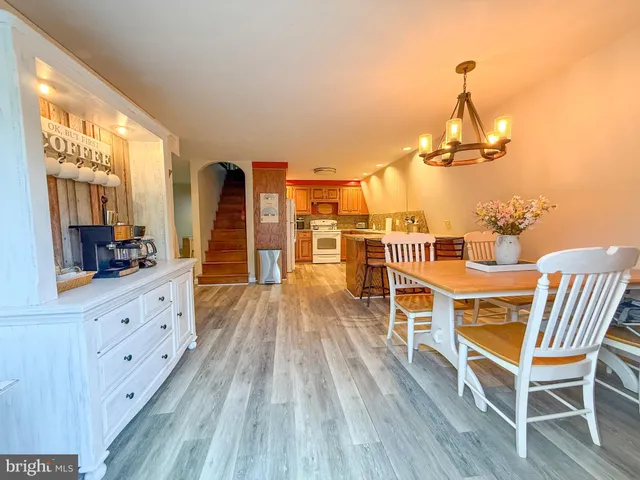 a view of a dining room with furniture a chandelier and wooden floor