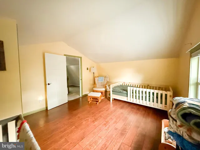 a spacious bedroom with a bed and a flat screen tv