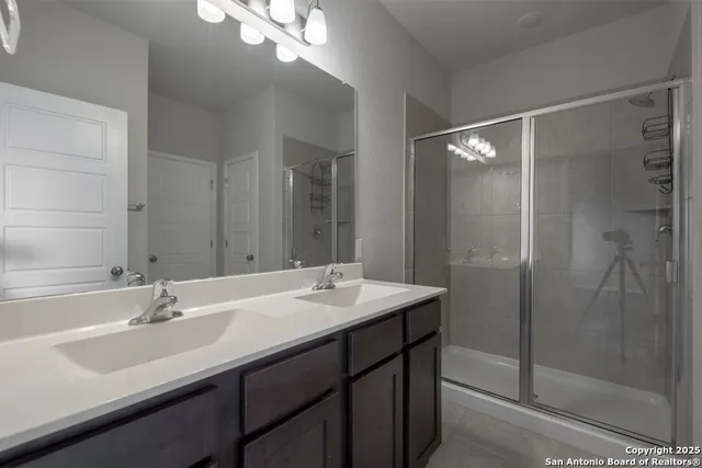 a bathroom with a sink double vanity and shower