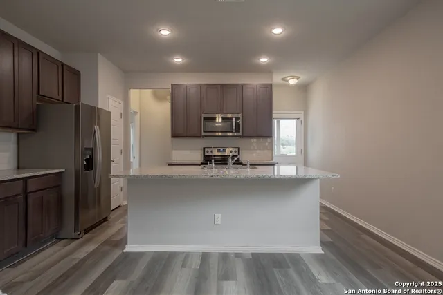 a kitchen with stainless steel appliances a refrigerator and a stove top oven