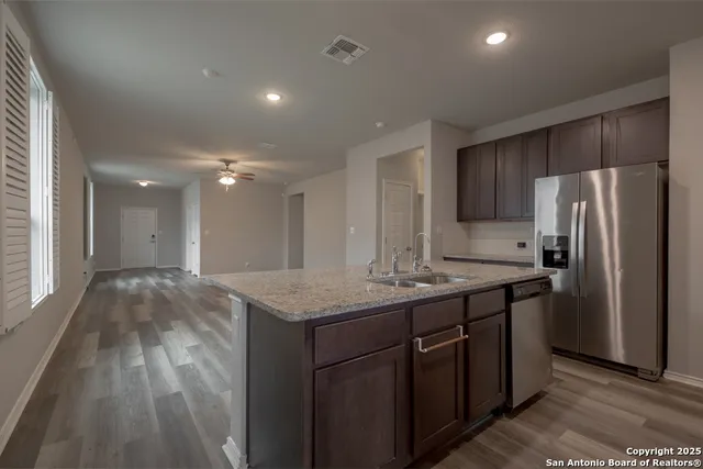 a kitchen with kitchen island a sink stove and refrigerator