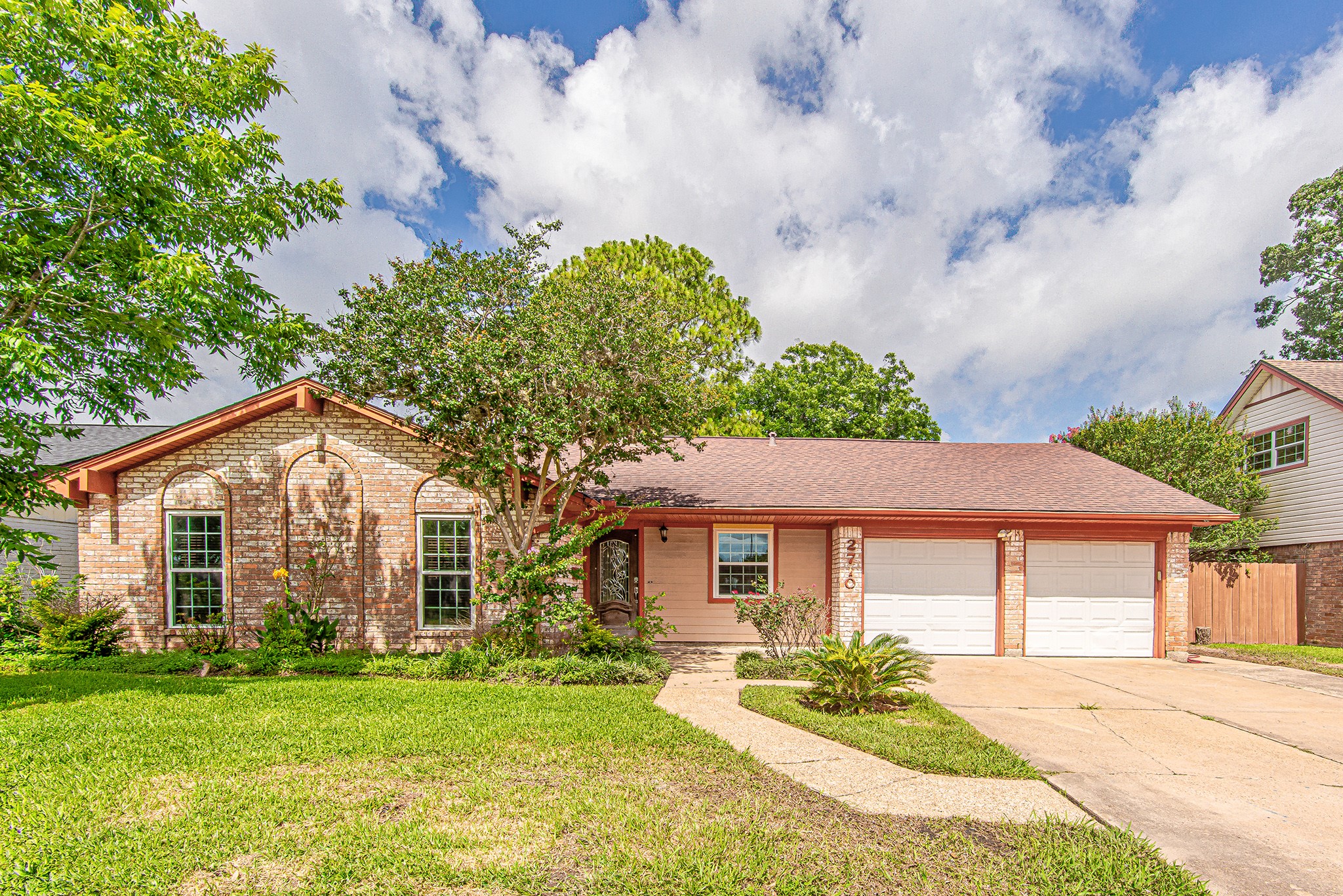 Charming brick exterior with mature landscaping and inviting curb appeal