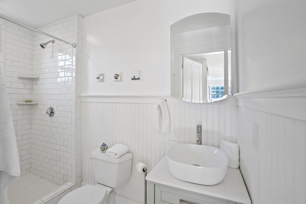 187 Lagoon Pond Road Tisbury, MA 02568 - Photo 11 of 27 a bathroom with a toilet a sink a shower and mirror
