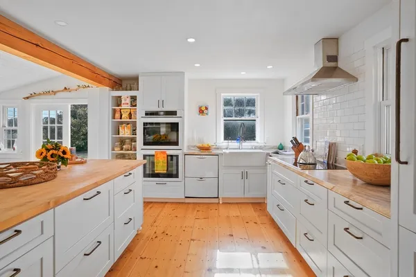 a large white kitchen with cabinets