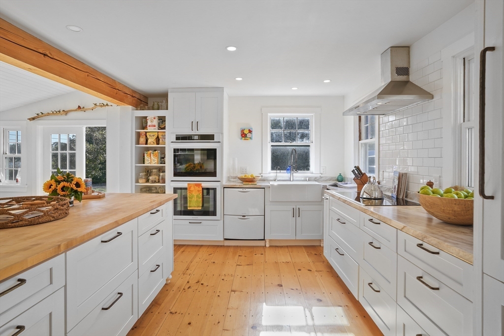 187 Lagoon Pond Road Tisbury, MA 02568 - Photo 10 of 27 a large white kitchen with cabinets