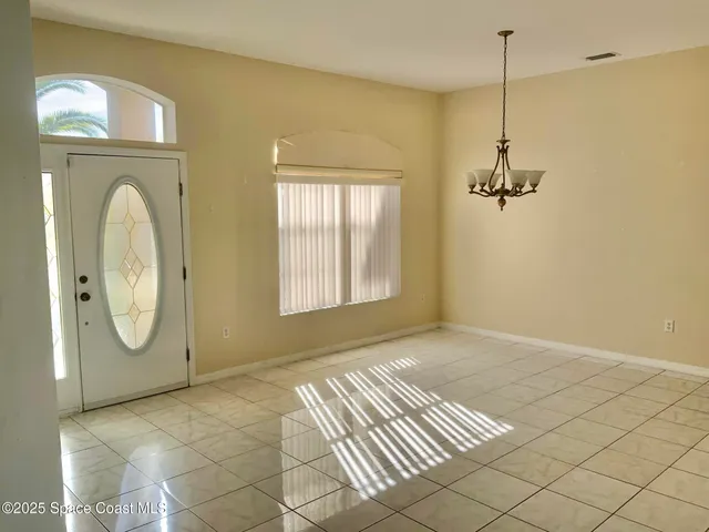a view of a room with wooden floor fan and windows