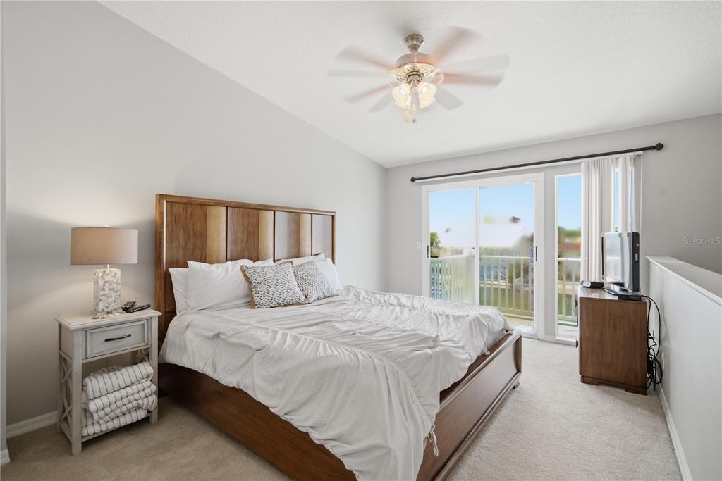 643 Garland Circle Indian Rocks Beach, FL 33785 - Photo 35 of 81 a bedroom with a large bed and a chandelier fan
