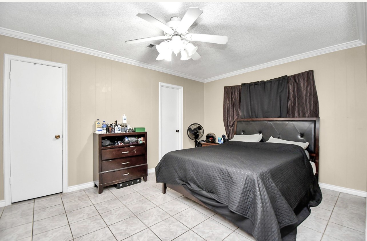 712 Meadowick Drive Baytown, TX 77521 - Photo 14 of 21 a bedroom with a bed and a chandelier