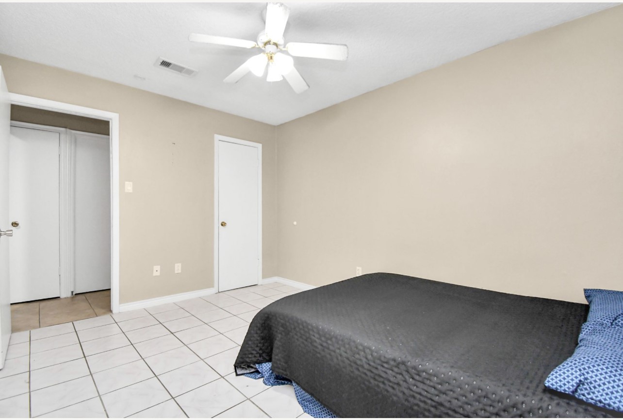712 Meadowick Drive Baytown, TX 77521 - Photo 16 of 21 a bedroom with a bed and a chandelier fan