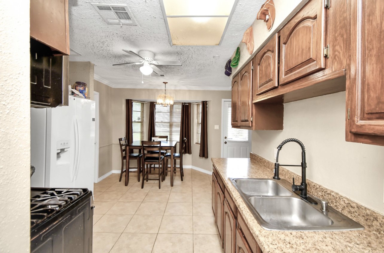 712 Meadowick Drive Baytown, TX 77521 - Photo 17 of 21 a kitchen with stainless steel appliances granite countertop a sink dishwasher and a stove with wooden floor